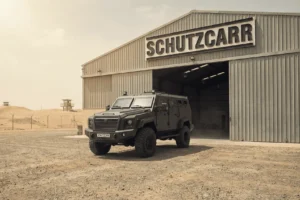 schutzcarr MRAP parked outside desert warehouse